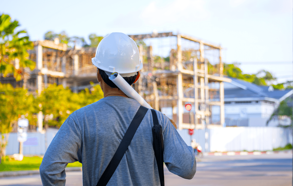 General Contractor General Contractor with plans over shoulder looking at worksite